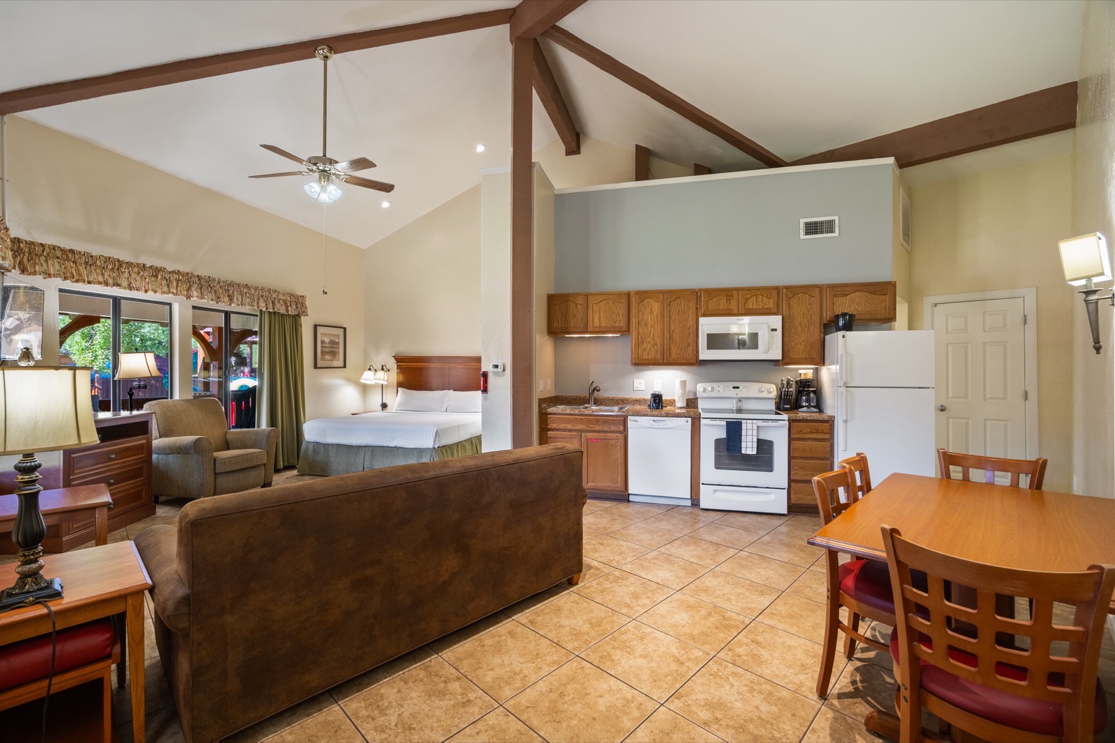 Studio apartment with exposed beam ceiling, full kitchen, and living area